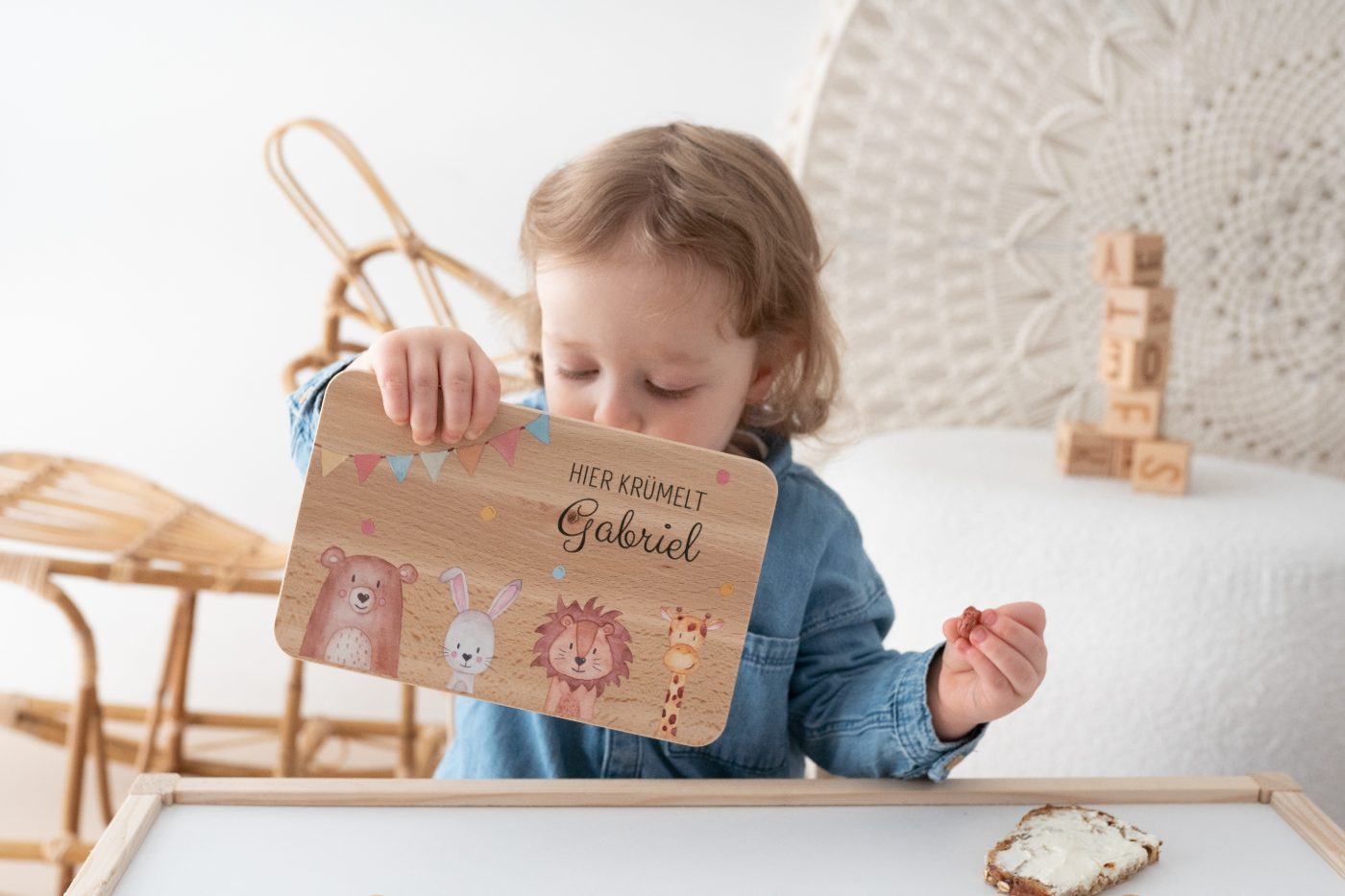 Kind mit personalisiertem Frühstücksbrettchen Hier krümelt Gabriel