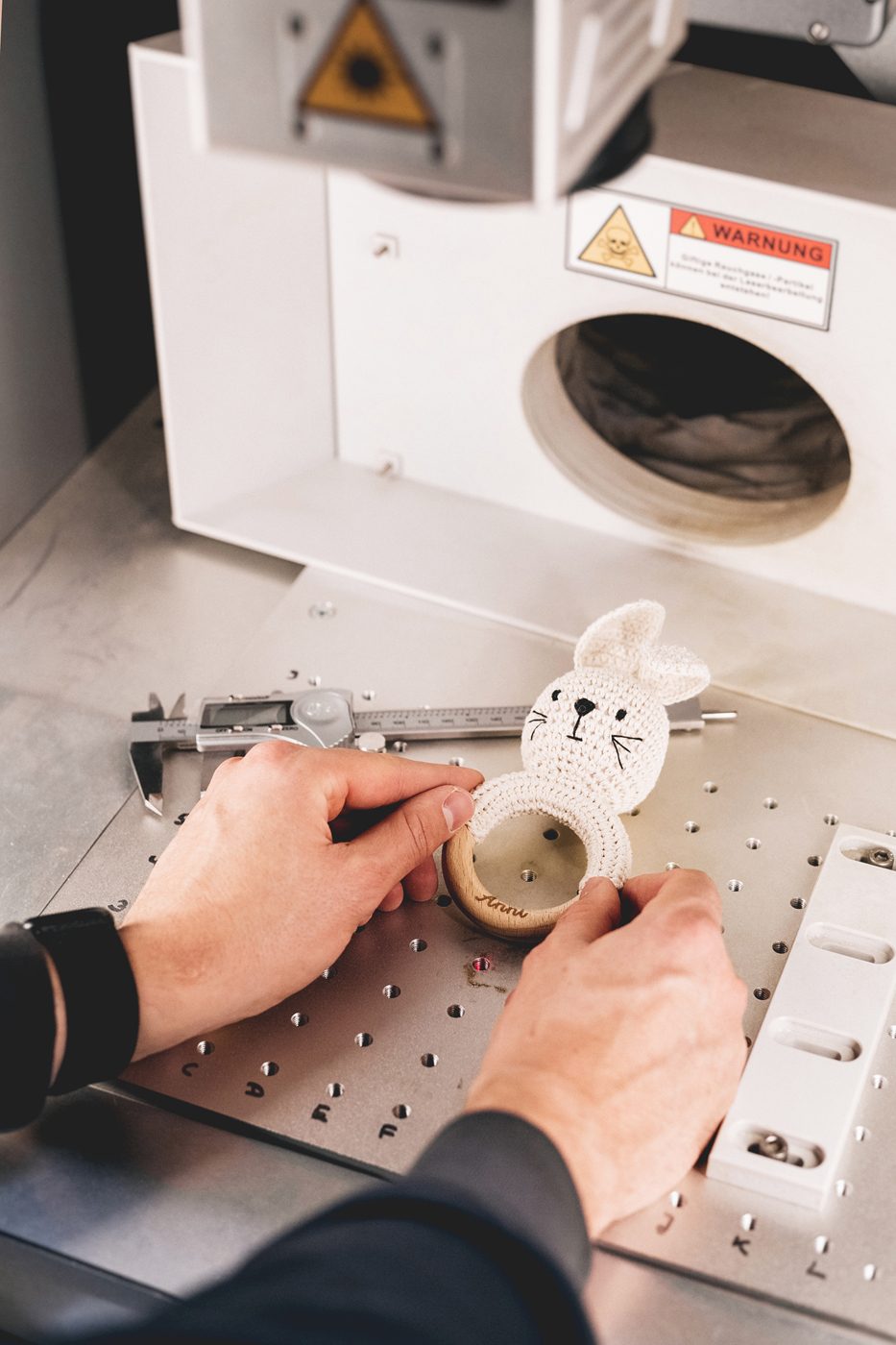 Greifling aus Holz mit gehäkeltem Hasen in der Lasermaschine