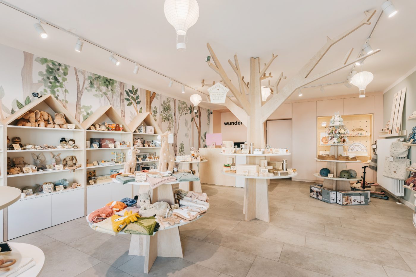 Innenansicht des Concept Stores mit großem Holzbaum